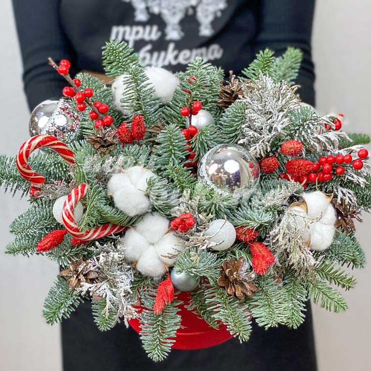 Леденцы и елочные игрушки в коробке (вид сверху)