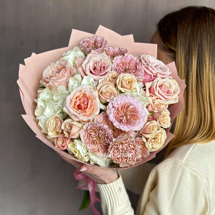 Нежно-розовый букет пионовидных и кустовых роз (в руках флориста)